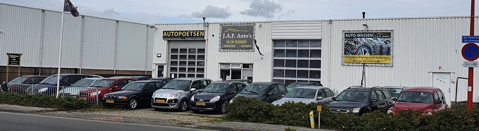 De werkplaats van J.A.F. Auto's aan De Hemmen 38b, met de borden autopoetsen, J.A.F. Auto's en auto-wassen en een rij auto's ervoor