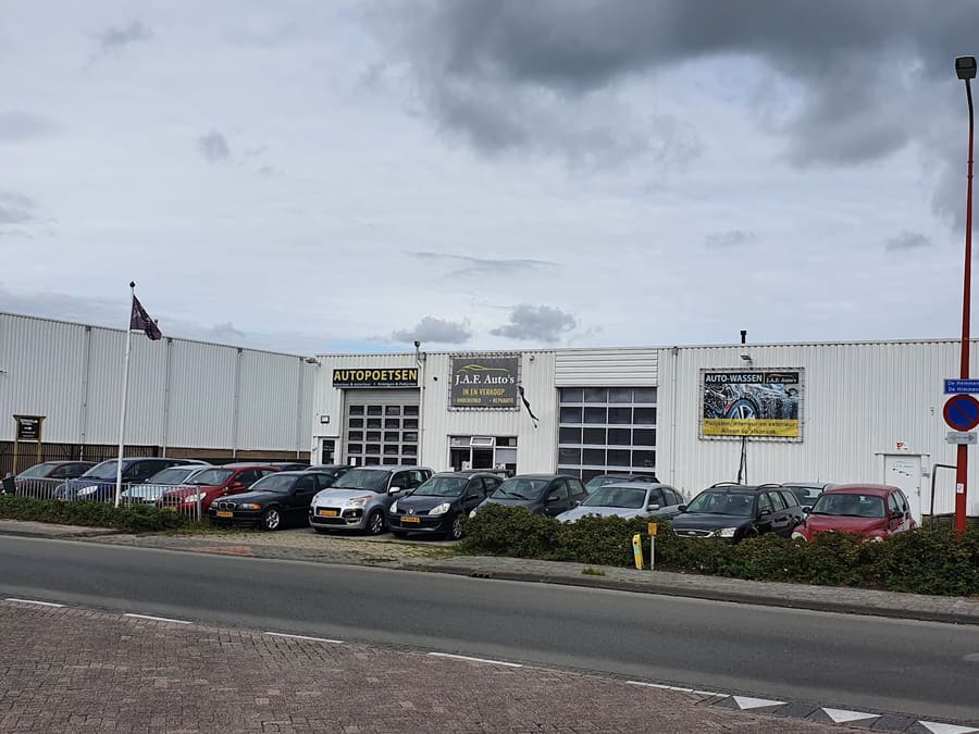 Overzicht van de werkplaats aan De Hemmen met auto's op het terrein